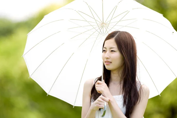 年轻美丽的日本女人在户外拿着白色的雨伞 — 图库照片
