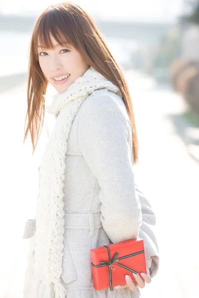 年轻的亚洲女人头戴冬衣 手持礼品盒的肖像 — 图库照片