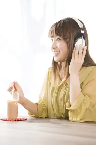 ヘッドフォンで音楽を聴く若いアジアの女性 — ストック写真