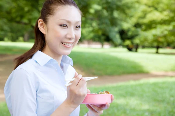 Genç Asyalı Kadın Parkta Yemek Yiyor — Stok fotoğraf