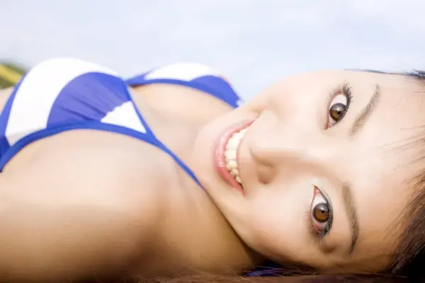 Sahilde Uzanmış Gülümseyen Asyalı Kadın Kameraya Bakıyor — Stok fotoğraf