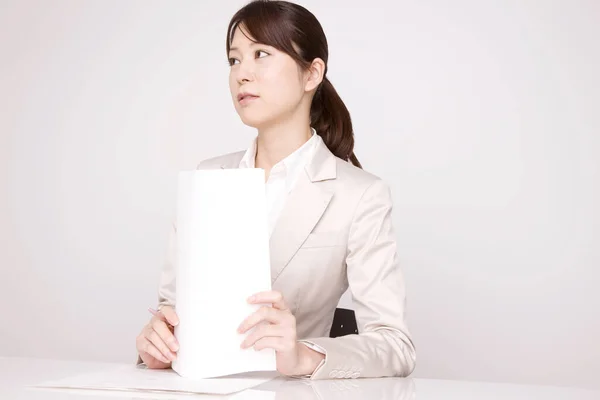 Joven Mujer Negocios Japonesa Sosteniendo Papeles Mirando Lado Lugar Trabajo —  Fotos de Stock