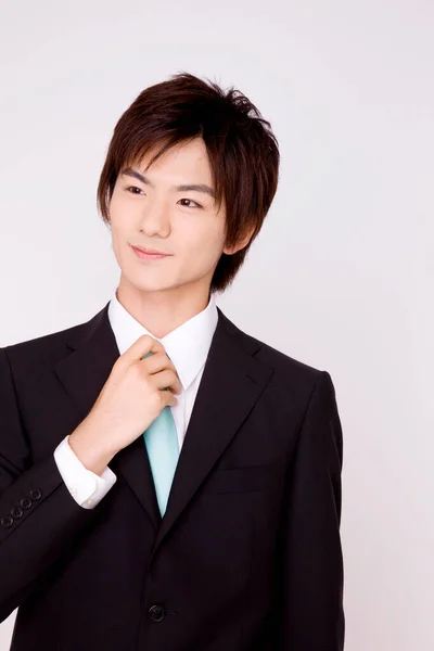 Fiatal Ázsiai Üzletember Igazítja Nyakkendőjét Elszigetelt Háttér — Stock Fotó