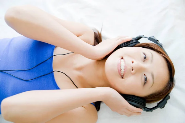 Genç Asyalı Kadın Yatakta Müzik Dinliyor — Stok fotoğraf