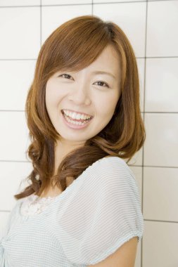 Beyaz arka planda, şık saç kesimi olan genç Japon kadının portresi. 