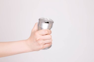 Beyaz arka planda alüminyum kutu tutan kadın eli
