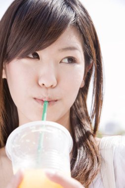 Plastik bardakta meyve suyu içen kadın yaklaş.