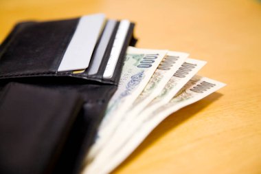 Cüzdanında kredi kartları ve tahtadan arka planda banknotlar var..