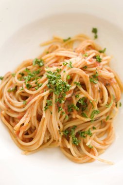 Beyaz tabakta maydanozlu makarna.