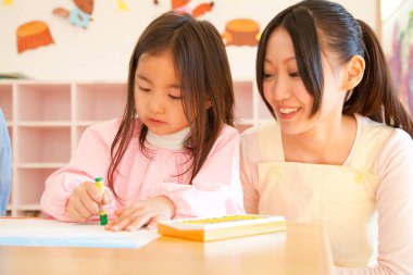 Annesiyle resim çizen tatlı Asyalı küçük kız.