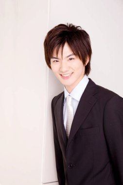 Genç Asyalı işadamı ofiste duruyor. 