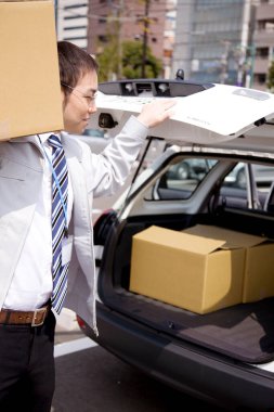 Karton kutulu genç Asyalı adamın portresi, teslimat hizmeti konsepti.