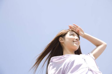 Gökyüzünde duran Asyalı kadın. 