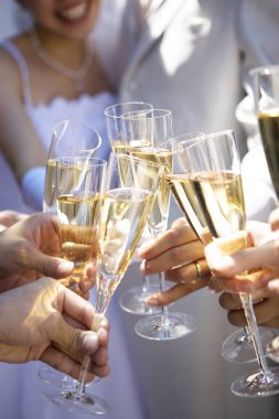 Yakın plan. Düğünde şampanya kadehleri tutan insanların fotoğrafı.