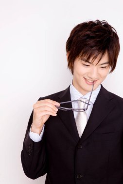 Genç Asyalı iş adamı, arka planda gözlük tutuyor. 