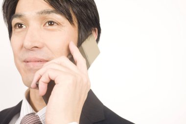 Beyaz arka planda yakışıklı genç Japon işadamının yakın plan portresi.