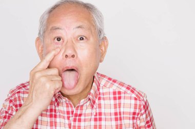 Asyalı kıdemli adam dil uzatıyor.