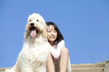 Şirin, mutlu Japon kızın yavru köpeğiyle portresi.