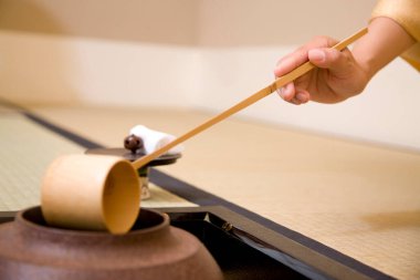 Bambu çırpıcılı kibrit çayı hazırlayan kadın.  