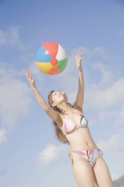 Mayo giymiş güzel bir Japon kadın gündüz kumsalda dinleniyor, yaz tatili konsepti.