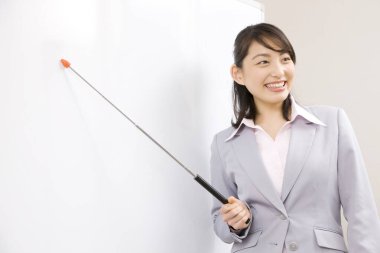 Elinde işaret olan genç bir kadın bir şey gösteriyor. 