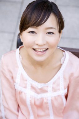 Bankta oturan genç Japon kadının yüksek açılı görüntüsü