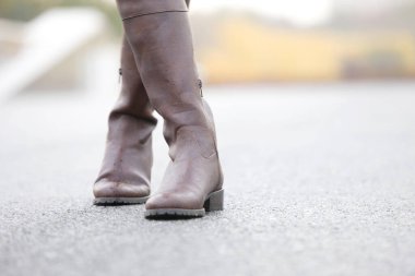 Deri çizmeli kadın bacakları kaldırımda, yaklaşın.