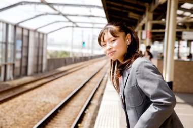 Tren istasyonunda kulaklıklı, güzel Asyalı bir kadın.