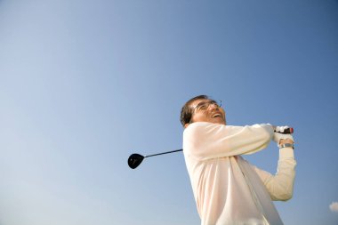 Son sınıf öğrencisi gökyüzüne karşı golf oynuyor. 
