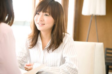 Kafede konuşan iki genç Asyalı kadının portresi. 