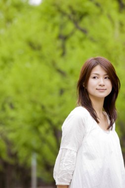 Güzel, mutlu, Asyalı bir kadının açık havada portresi.