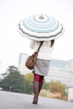 Şemsiyeli genç kadın, arka manzara.