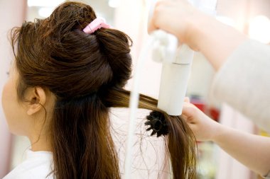 Genç Japon kadın kuaförde kuaförlük yapıyor. Güzel Japon bayan şık bir saç kesimi yapıyor. 