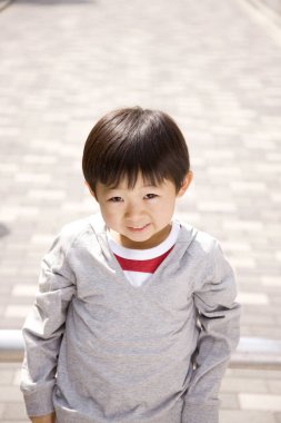 Sokakta oynayan küçük Japon çocuk.