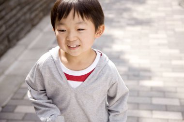 Sokakta oynayan küçük Japon çocuk.