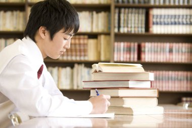 Kütüphanede okuyan bir ortaokul öğrencisi.