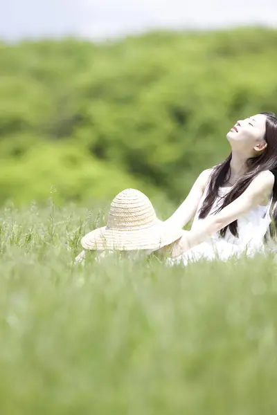 Vacker Ung Japansk Kvinna Håller Korgvide Hatt Och Sitter Grönt — Stockfoto