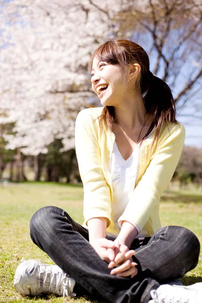 Atrakcyjna Młoda Azjatka Siedzi Trawie Śmieje Się Parku — Zdjęcie stockowe