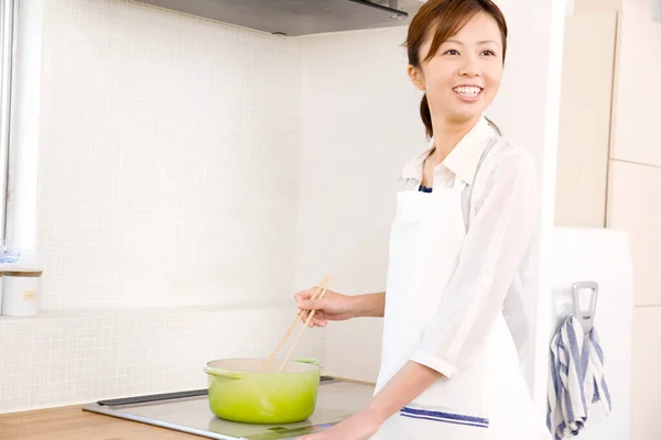 Usmívající Mladá Hospodyňka Vaření Večeře Moderní Kuchyni — Stock fotografie