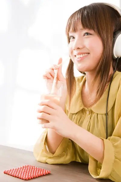 用耳机听音乐的年轻亚洲女人 — 图库照片