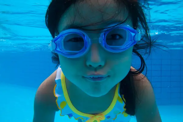 プールで水中ゴーグルと幸せなアジアの少女の肖像画 — ストック写真