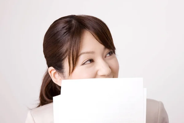 年轻的日本女商人笑着拿着灰色背景的文件 — 图库照片