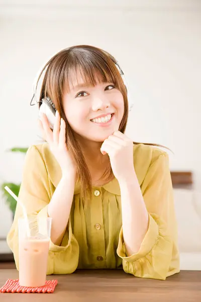 用耳机听音乐的年轻亚洲女人 — 图库照片