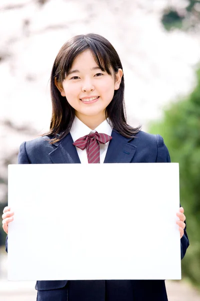 白い空白を示す日本の若い女の子の学生 — ストック写真