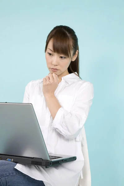 Mavi Arka Planda Dizüstü Bilgisayar Kullanan Güzel Genç Asyalı Bir — Stok fotoğraf