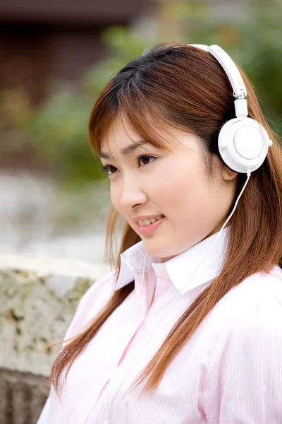 ヘッドフォンで音楽を聴く日本の若い女性 — ストック写真