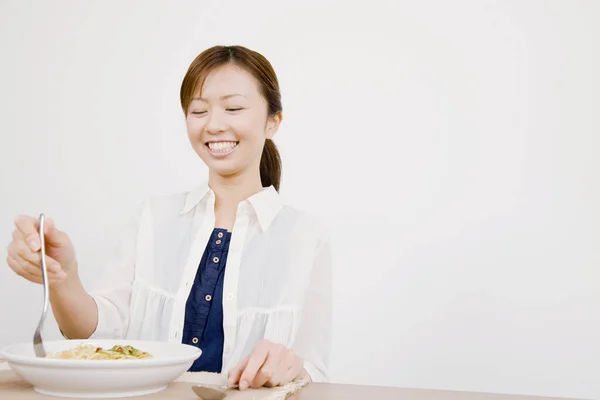 用叉子笑亚洲女人吃面条 — 图库照片