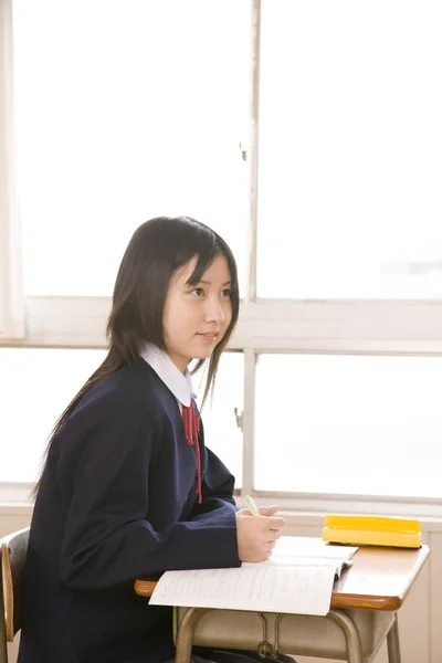 Japońska Uczennica Siedzi Przy Szkolnym Biurku Portret Ślicznotki Szkolnym Mundurze — Zdjęcie stockowe