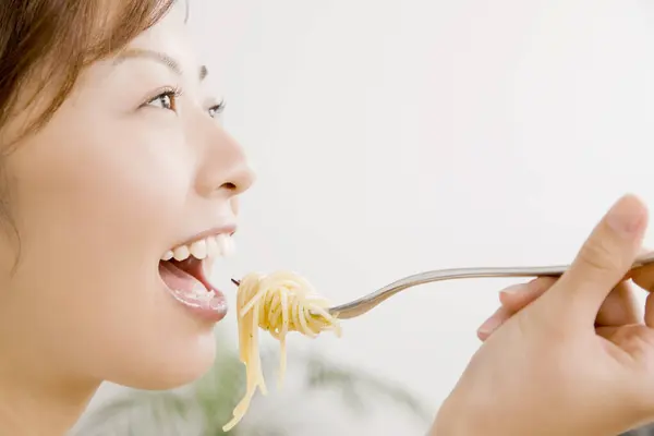 吃意大利面的年轻亚洲女人 — 图库照片