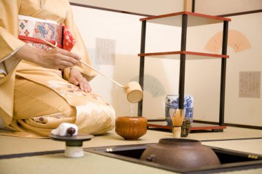 Kimonolu kadın çay yapıyor.